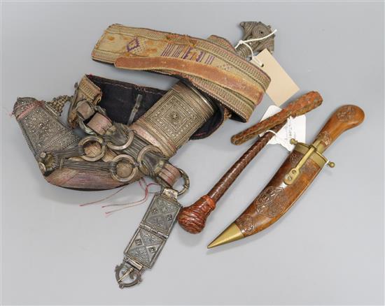 An Omani khanjar in decorative white metal-mounted wooden scabbard on woven belt and two other items,